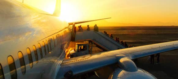 Passengers Boarding Plane at Sunset on Tarmac