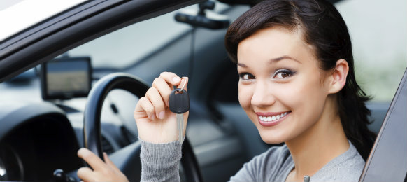 young woman showing off her car rental keys