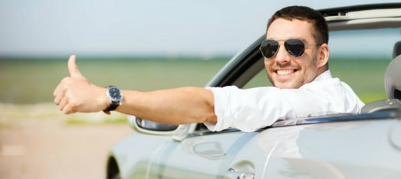 dapper guy posing at camera inside his car