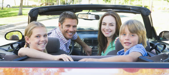 happy family in convertible car smilin