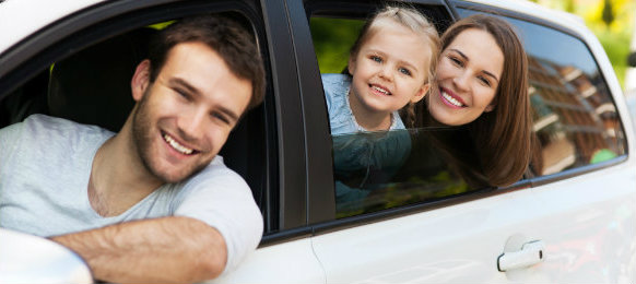 happy family posing inside their car