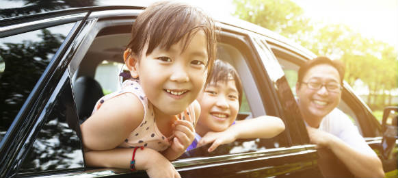 happy little girl with her family in a car rental for vacation