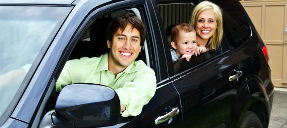 happy young family sitting in black car rental looking out windows