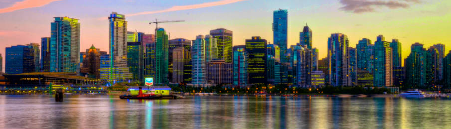 vancouver with tall buildings and city lights, plus the sunset