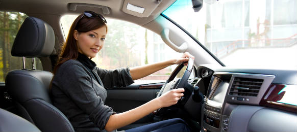 young woman driving the new car rental